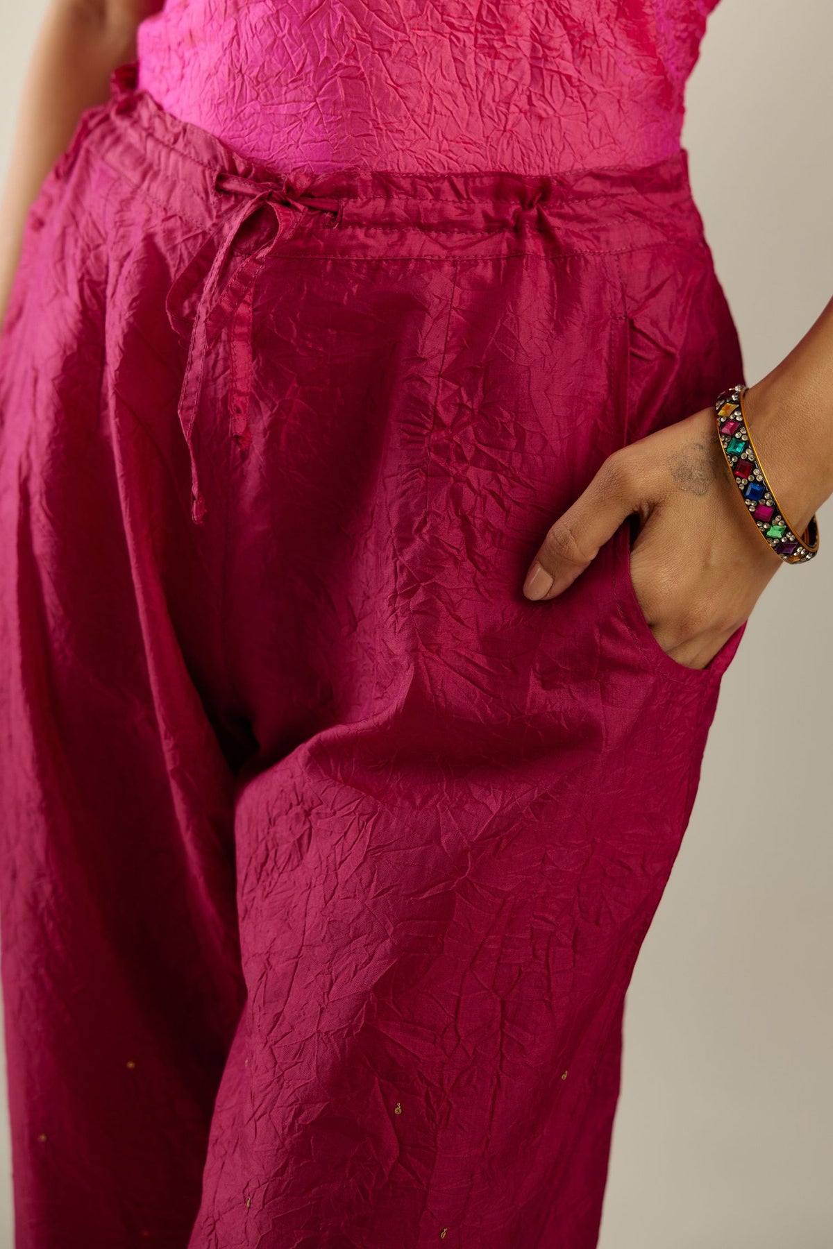 Jazzberry jam hand crushed silk straight pants detailed with gold sequins at hem and a single sequin buti is sprayed all over the pants and side pockets