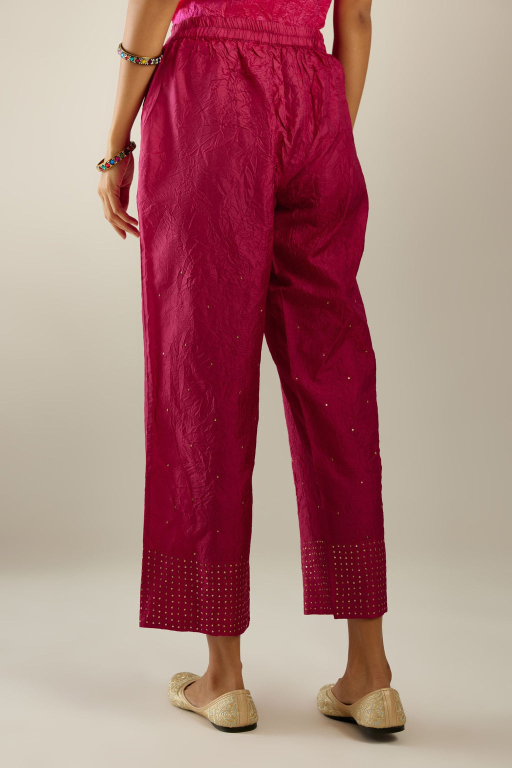 Jazzberry jam hand crushed silk straight pants detailed with gold sequins at hem and a single sequin buti is sprayed all over the pants and side pockets