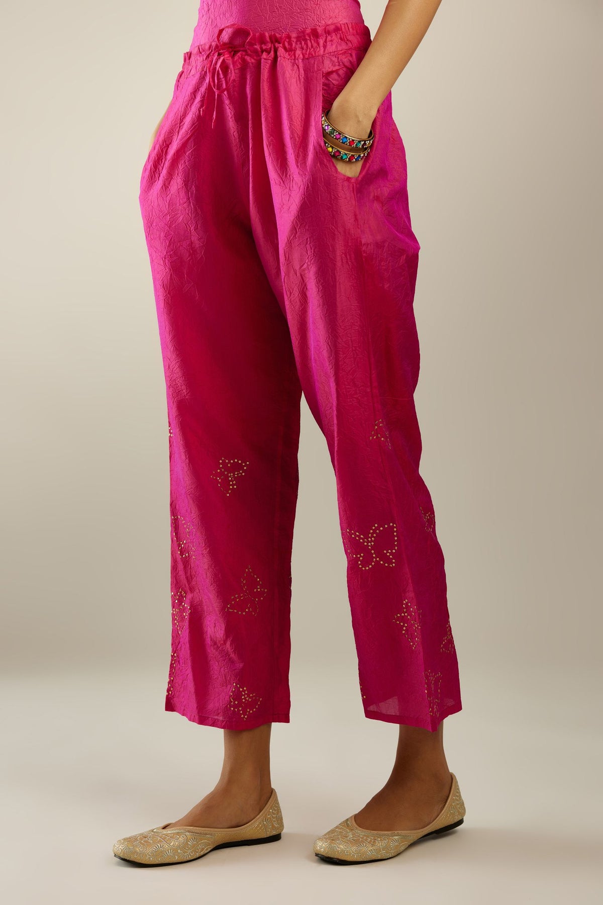 Raspberry crushed silk pants with side pockets and assorted sequined butterflies till mid-calf length.