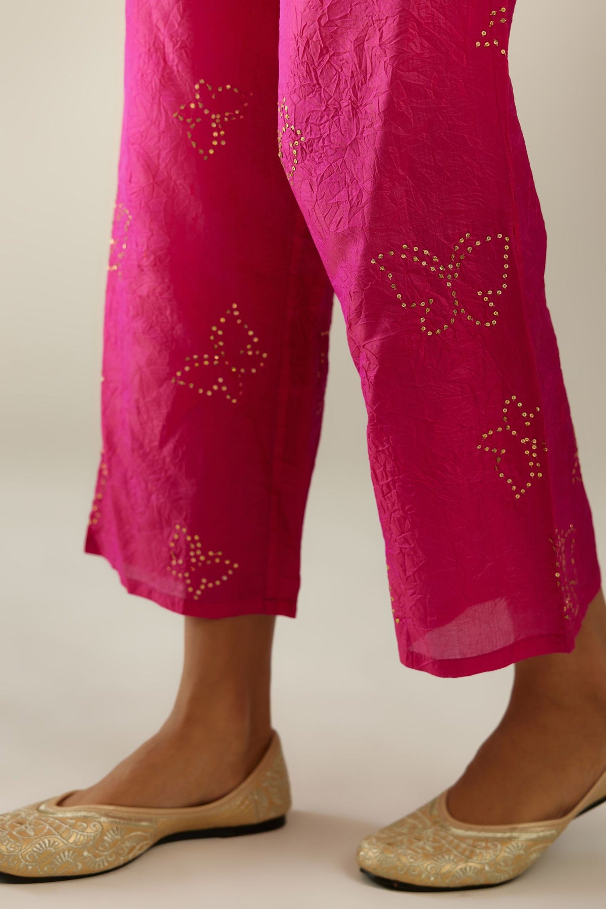Raspberry crushed silk pants with side pockets and assorted sequined butterflies till mid-calf length.