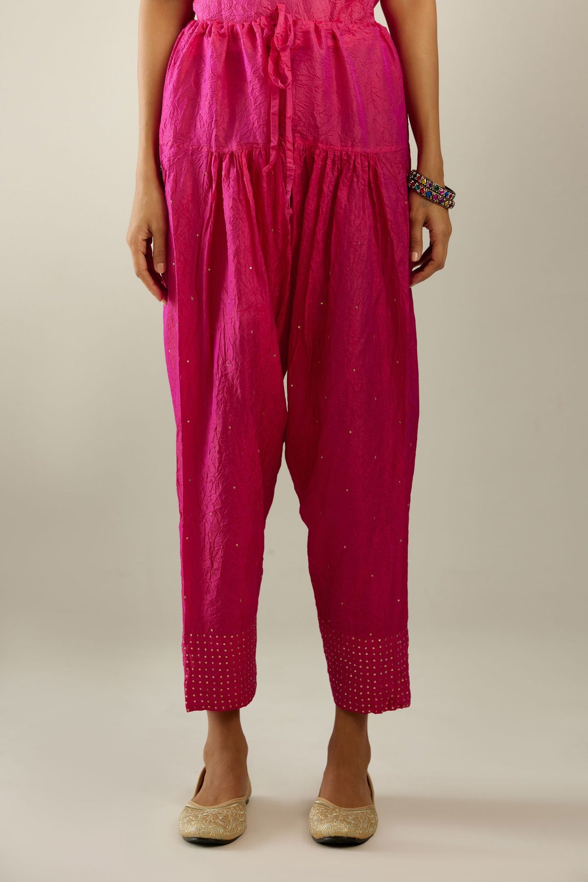 Raspberry hand crushed pure silk narrow salwar detailed with gold sequins at hem.