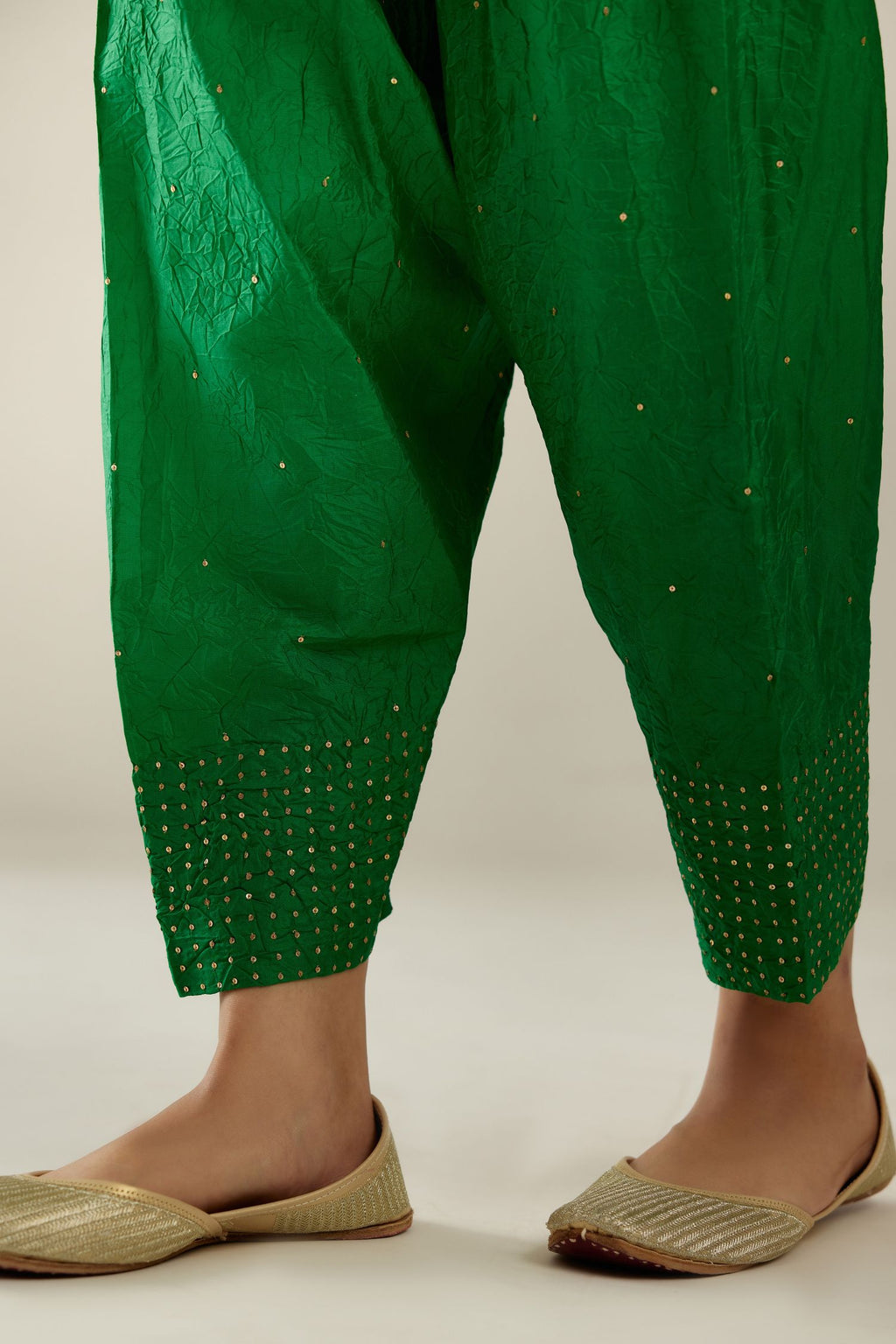 Grass green hand crushed pure silk narrow salwar detailed with gold sequins at hem.