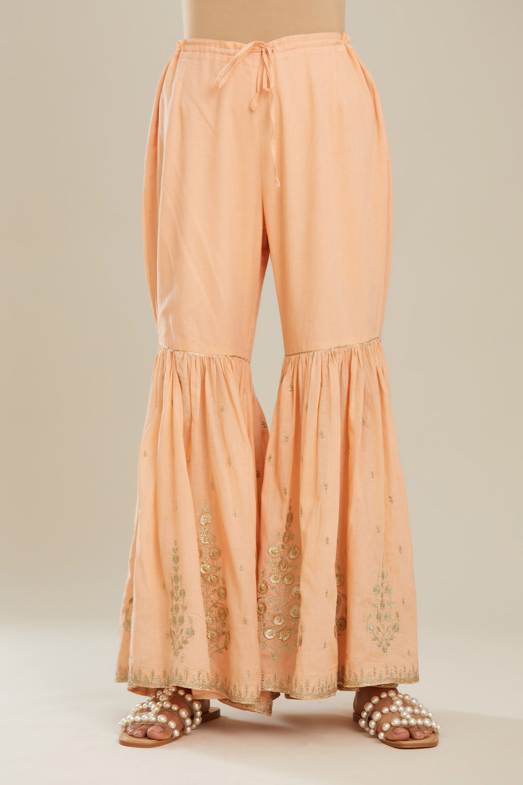 Peach farshi with gold zari and gota embroidery and gota detailing at knee joint seam. (Farshi)