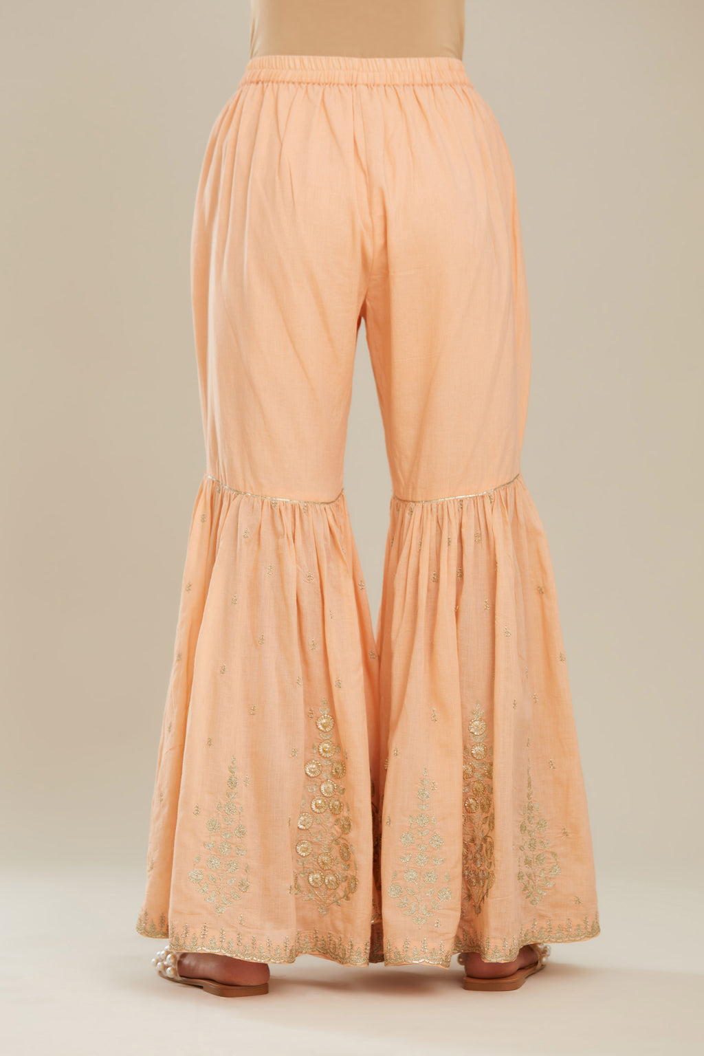 Peach farshi with gold zari and gota embroidery and gota detailing at knee joint seam. (Farshi)