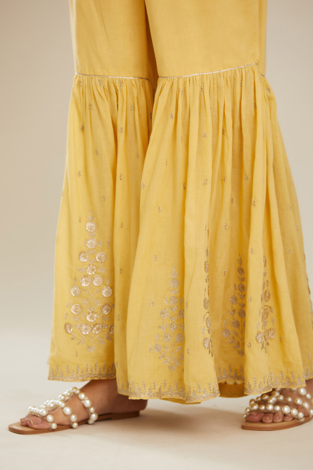 Yellow farshi with gold zari and gota embroidery and gota detailing at knee joint seam. (Farshi)