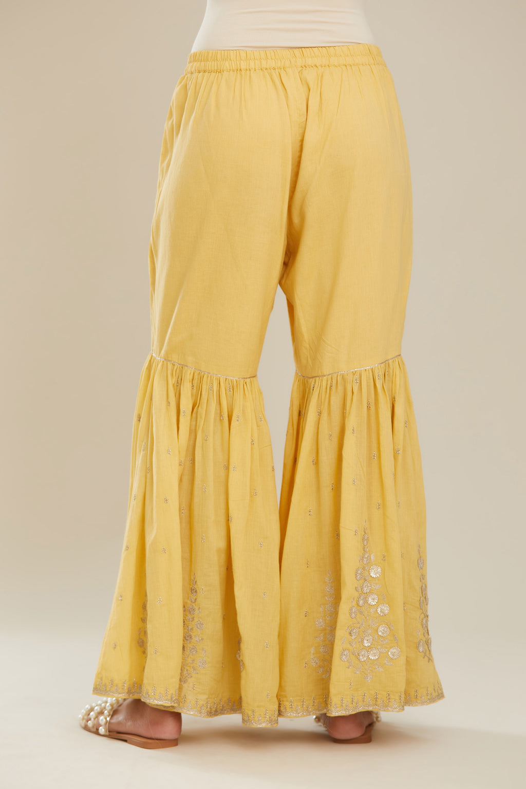 Yellow farshi with gold zari and gota embroidery and gota detailing at knee joint seam. (Farshi)