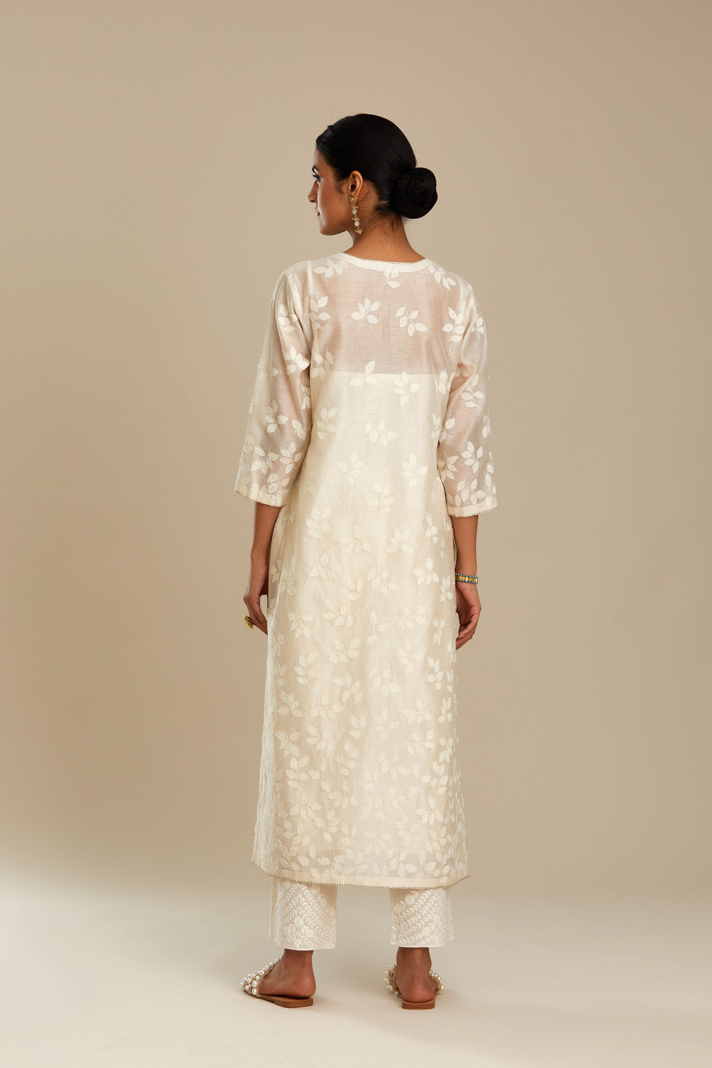Off white silk chanderi straight kurta set with graded leaf appliqué and sequin detail at edges.