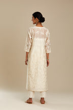 Off white silk chanderi straight kurta set with graded leaf appliqué and sequin detail at edges.