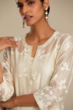 Off white silk chanderi straight kurta set with graded leaf appliqué and sequin detail at edges.