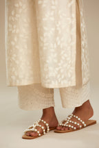 Off white silk chanderi straight kurta set with graded leaf appliqué and sequin detail at edges.
