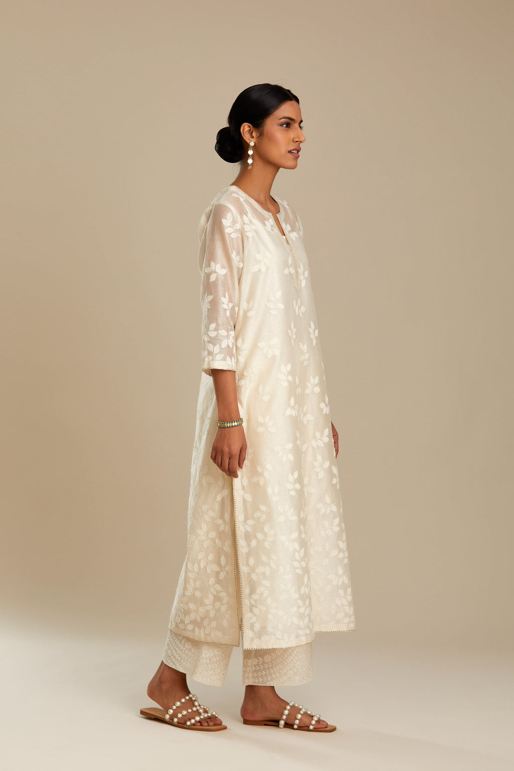 Off white silk chanderi straight kurta set with graded leaf appliqué and sequin detail at edges.