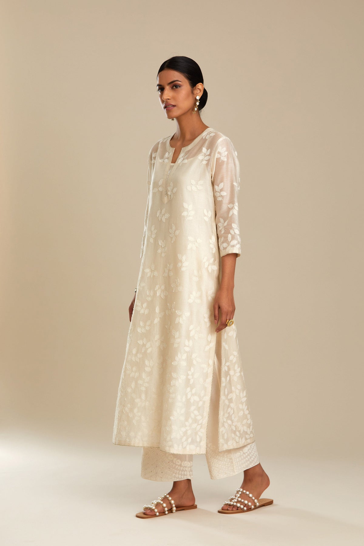 Off white silk chanderi straight kurta set with graded leaf appliqué and sequin detail at edges.