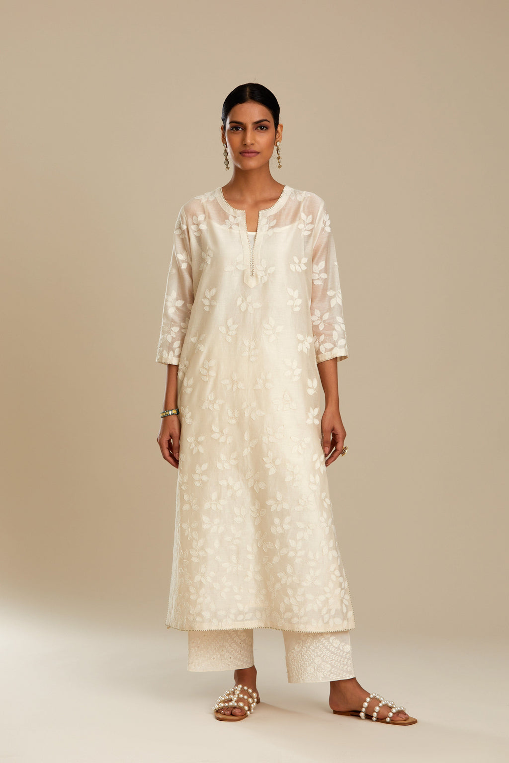 Off white silk chanderi straight kurta set with graded leaf appliqué and sequin detail at edges.