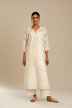 Off white silk chanderi straight kurta set with graded leaf appliqué and sequin detail at edges.