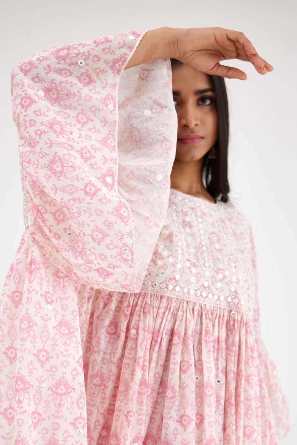Ikat design pink and off white hand block printed cotton easy fit top with flared sleeves and hem, paired with hand-block printed striped Cotton comfortable fit pant with all-over elasticated waisband.