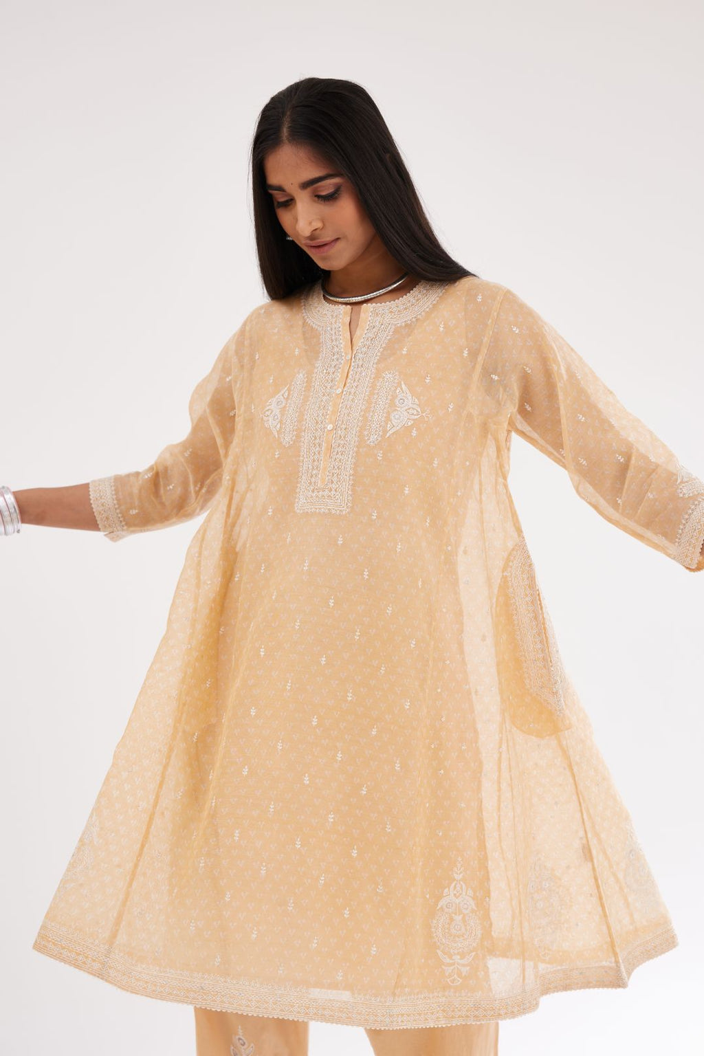 Peach cotton chanderi hand block printed short kalidar phiran style kurta set with button placket neckline and dori and silk thraed embroidery all over.