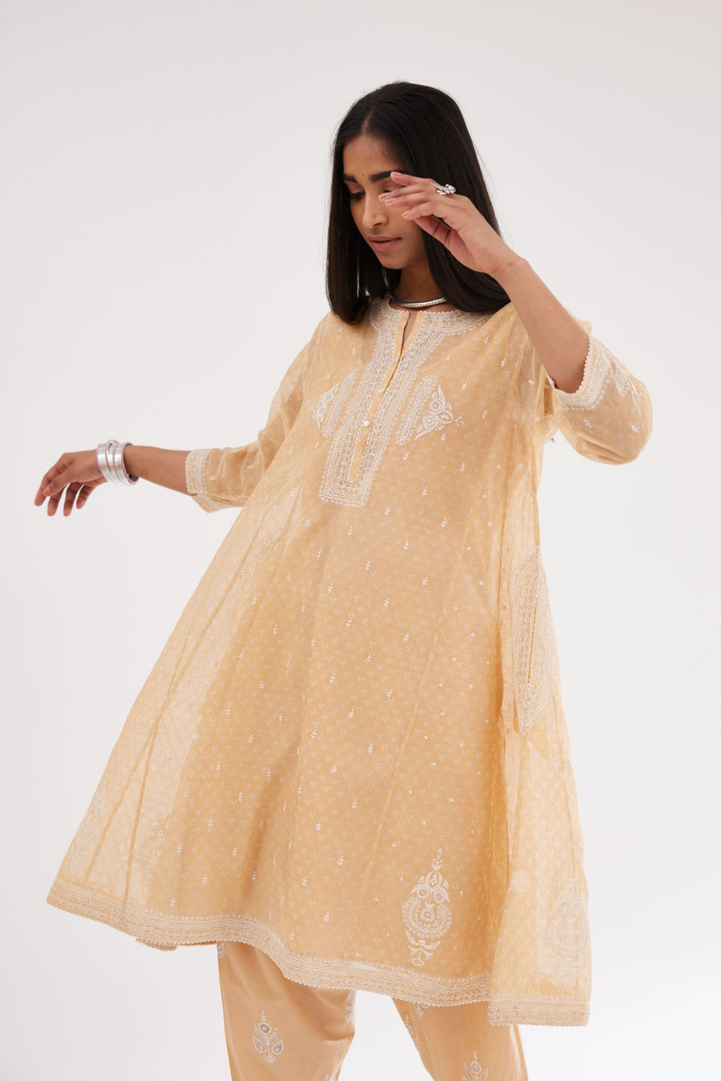 Peach cotton chanderi hand block printed short kalidar phiran style kurta set with button placket neckline and dori and silk thraed embroidery all over.