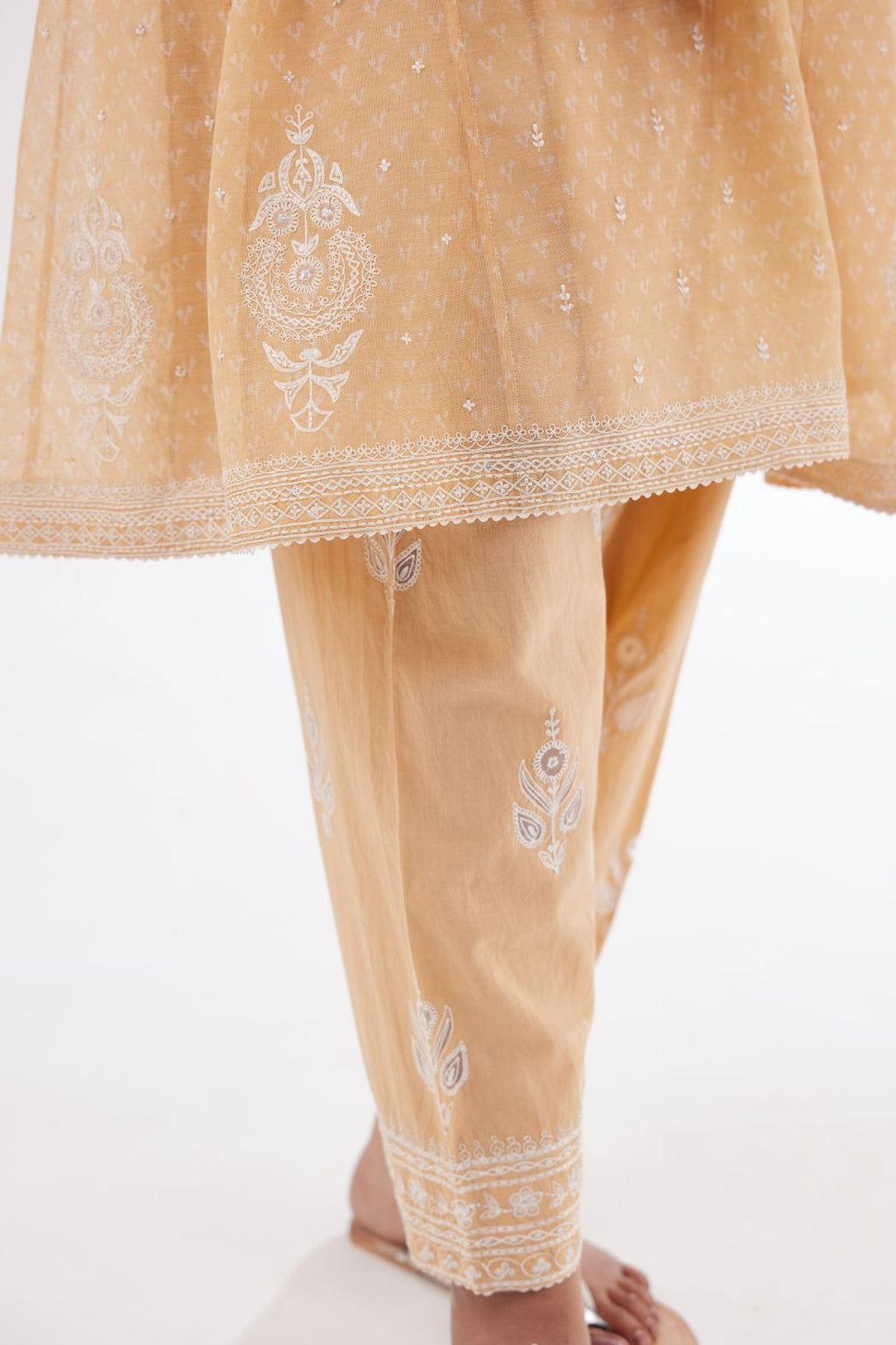 Peach cotton chanderi hand block printed short kalidar phiran style kurta set with button placket neckline and dori and silk thraed embroidery all over.