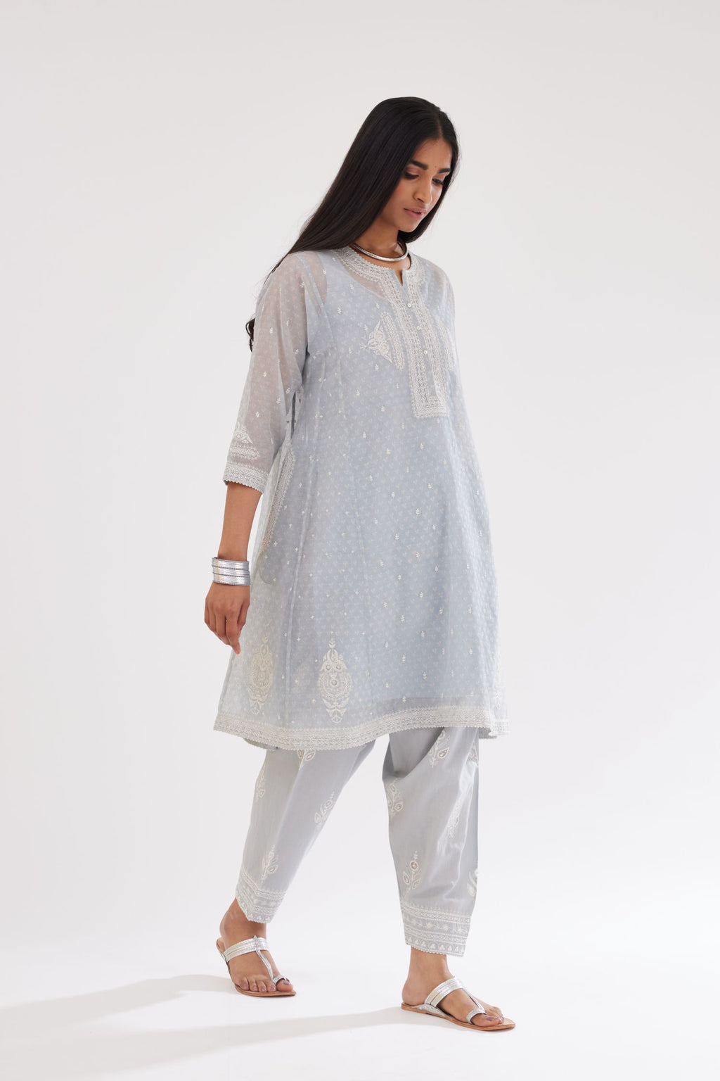Blue cotton chanderi hand block printed short kalidar phiran style kurta set with button placket neckline and dori and silk thraed embroidery all over.