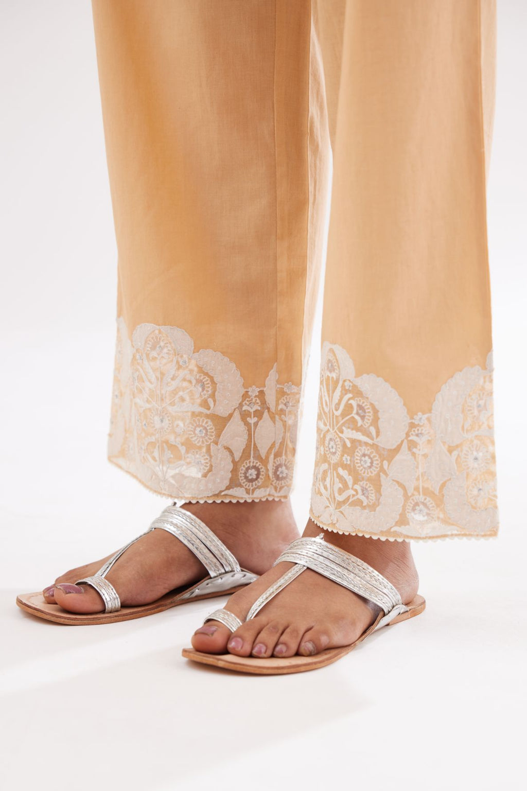 Peach cotton straight pants with appliqué and hand attached sequins detailing at bottom hem.