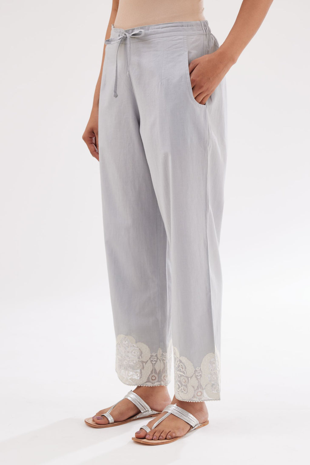 Blue cotton straight pants with appliqué and hand attached sequins detailing at bottom hem.