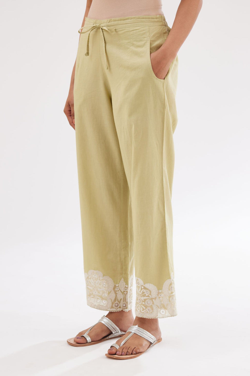 Green cotton straight pants with appliqué and hand attached sequins detailing at bottom hem.