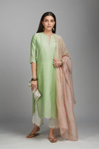 Lime green straight kurta set with silver zari embroidery at neck and scalloped hem