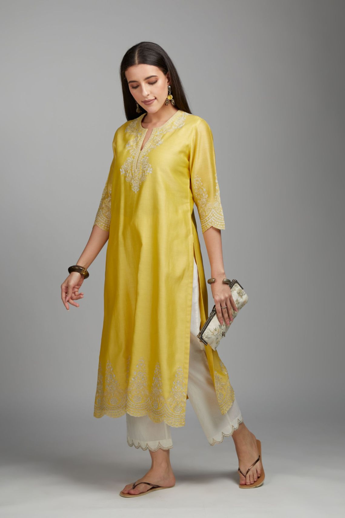 Yellow straight kurta set with silver zari embroidery at neck and scalloped hem