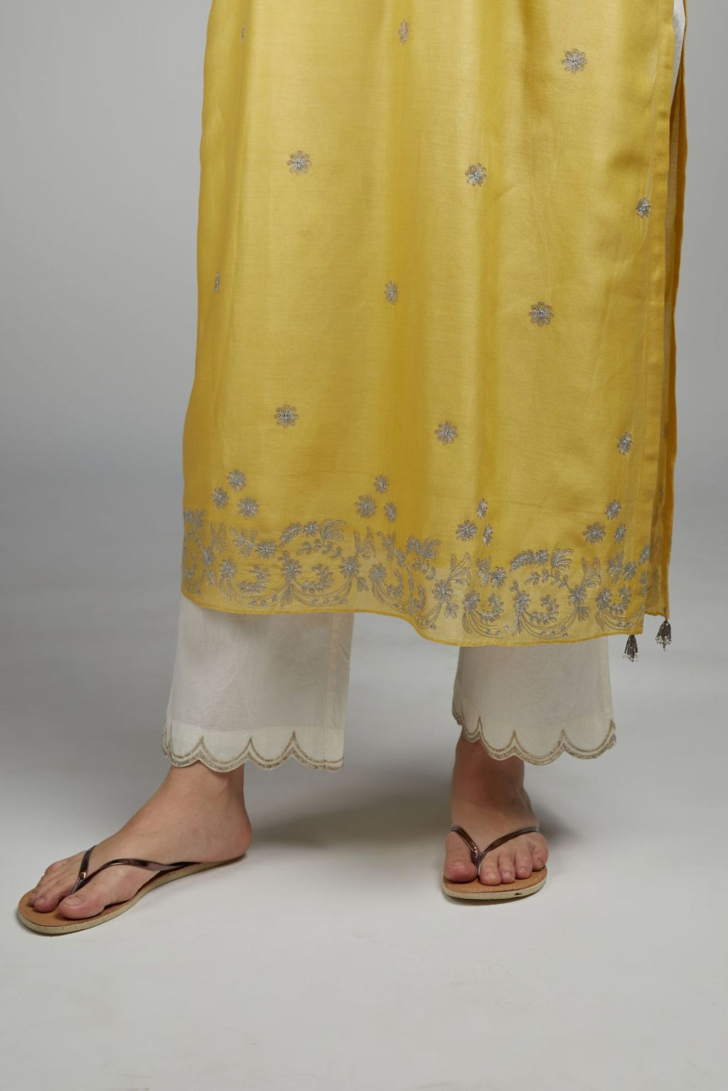 Yellow straight kurta set with silver zari embroidery and round neckline with button placket in the front