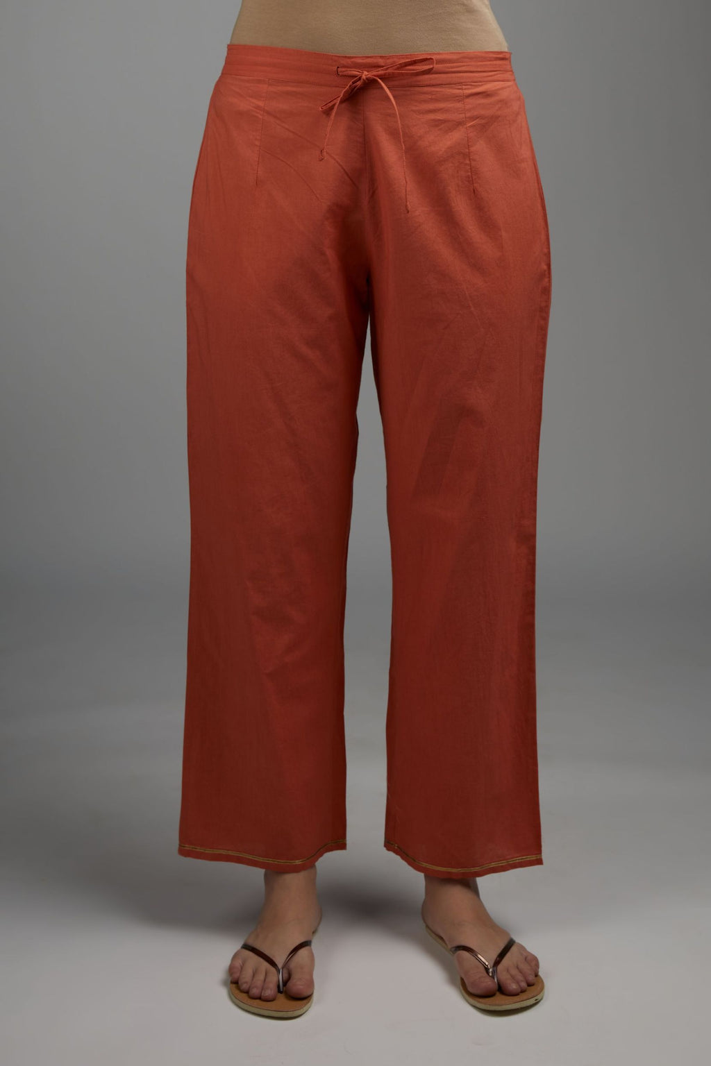 Rust straight cotton pants with single gota line detailing at hem