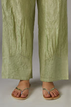 Apple green straight crushed silk pants with pin tucks at hem