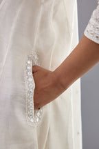 Off white silk Chanderi short panelled kurta set with off-white thread and mirror embroidery.