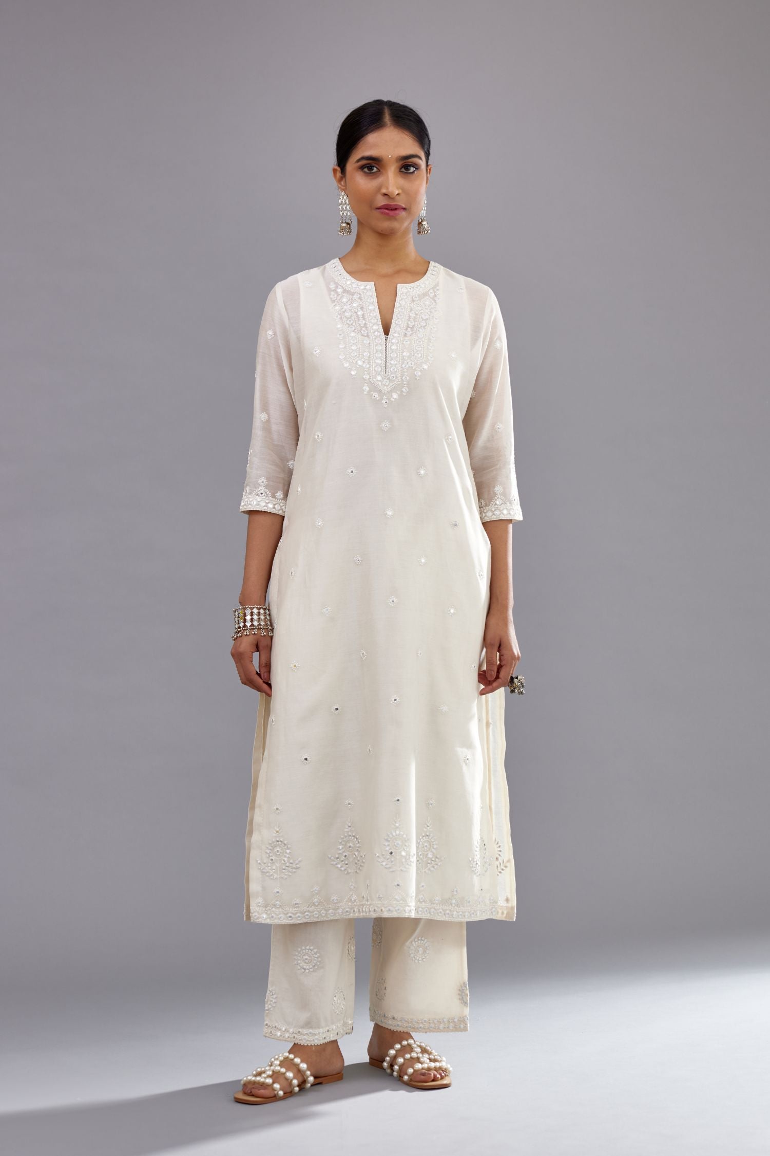 Off white silk Chanderi straight long kurta set with round neck, highlighted with off-white thread and mirror embroidery.