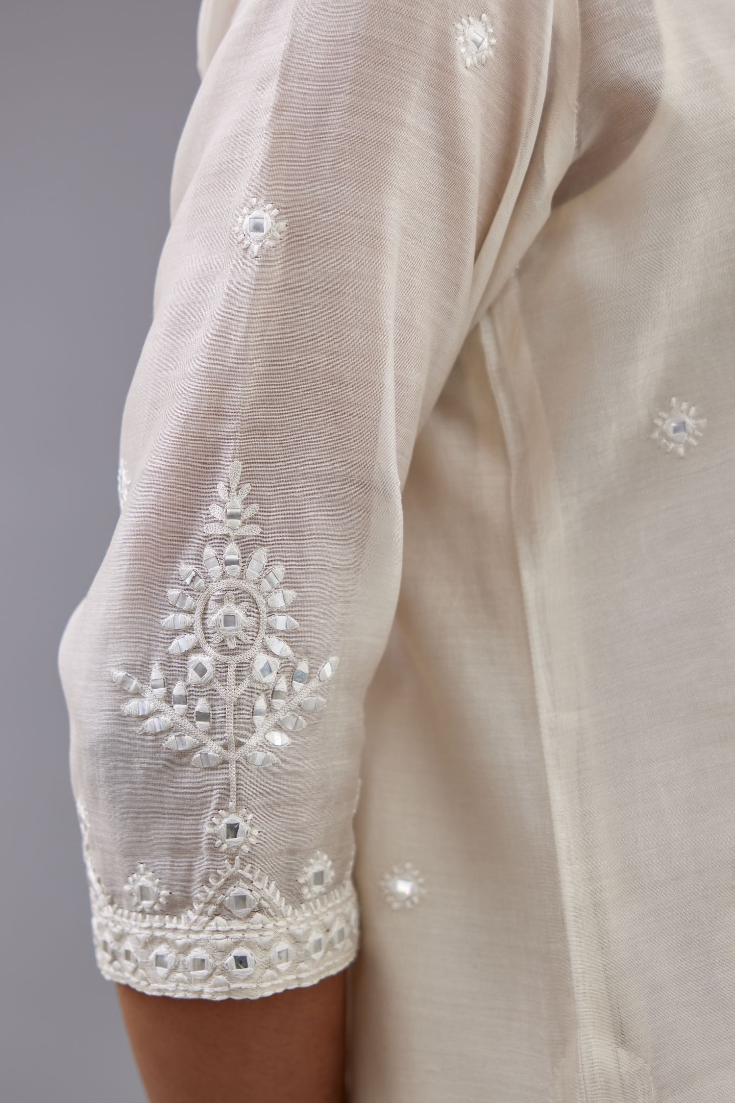 Off white silk Chanderi straight long kurta set with round neck, highlighted with off-white thread and mirror embroidery.