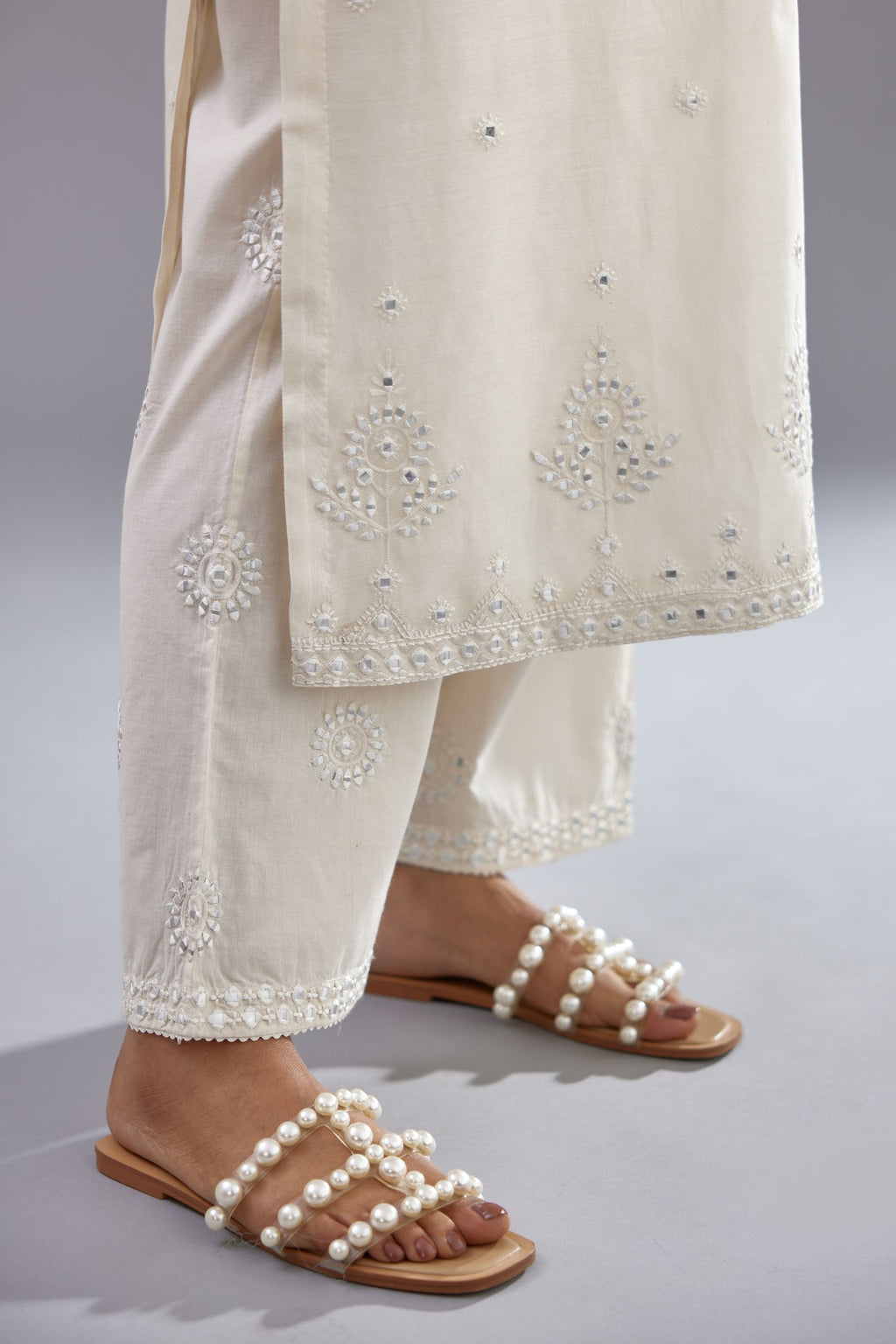Off white silk Chanderi straight long kurta set with round neck, highlighted with off-white thread and mirror embroidery.