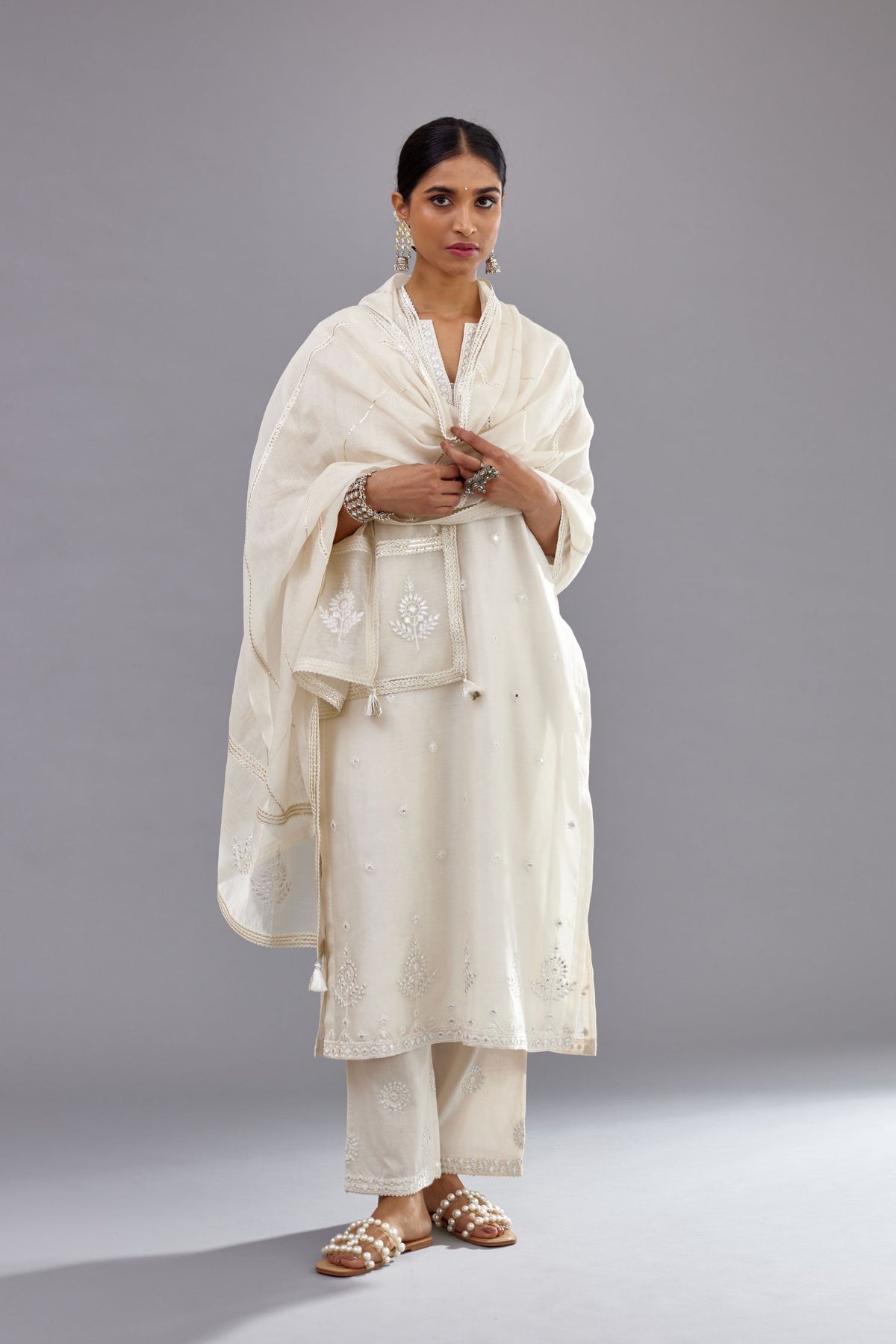 Off white silk Chanderi straight long kurta set with round neck, highlighted with off-white thread and mirror embroidery.