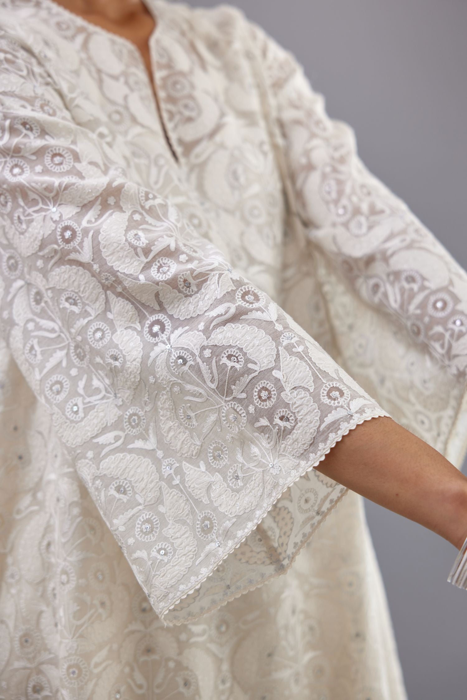 Off white short easy fit, straight hem kurta set with all-over trellis jaal appliqué, highlighted with sequins.