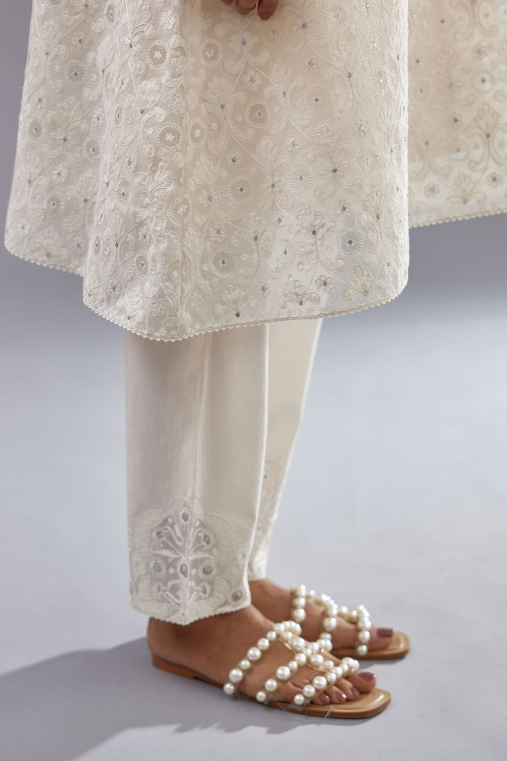 Off white short easy fit, straight hem kurta set with all-over trellis jaal appliqué, highlighted with sequins.