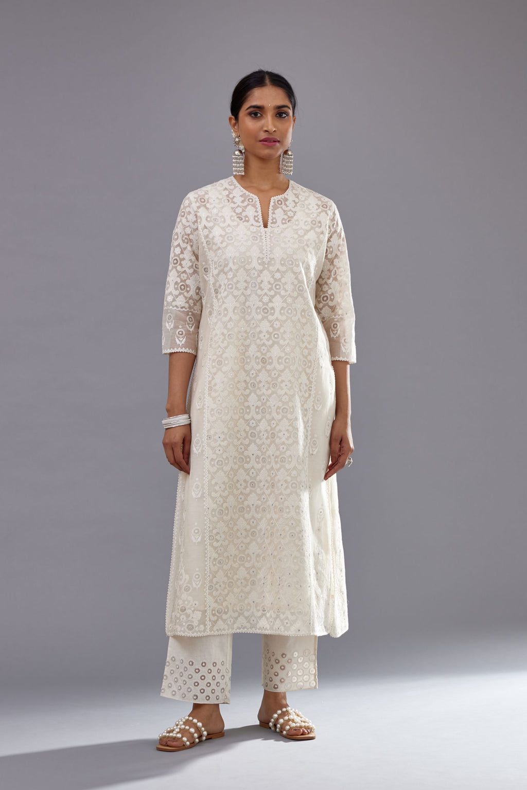 Off white silk chanderi straight kurta set with appliqué trellis jaal in center panel and small assorted flowers embroidery at side panells.