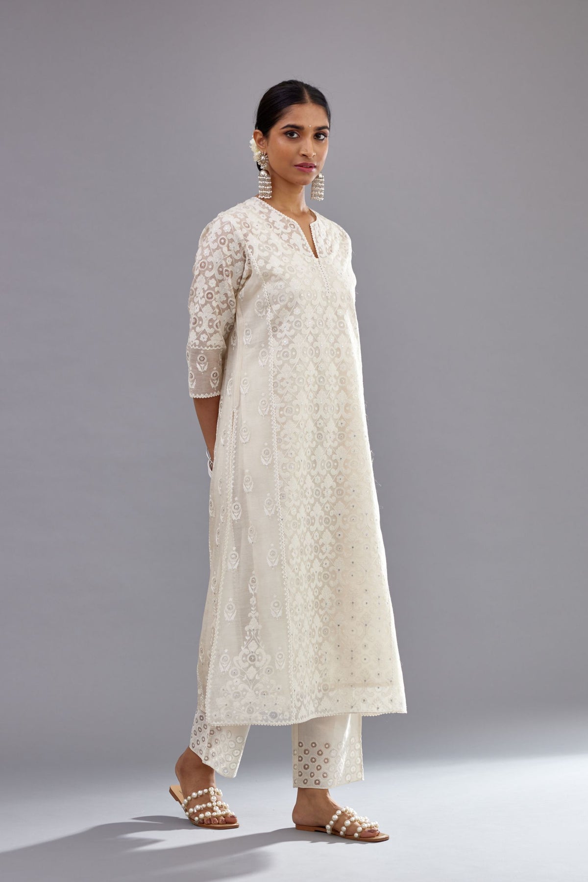 Off white silk chanderi straight kurta set with appliqué trellis jaal in center panel and small assorted flowers embroidery at side panells.