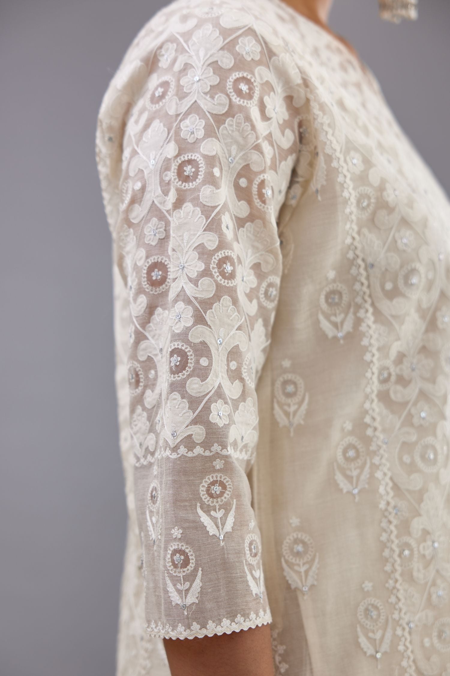 Off white silk chanderi straight kurta set with appliqué trellis jaal in center panel and small assorted flowers embroidery at side panells.