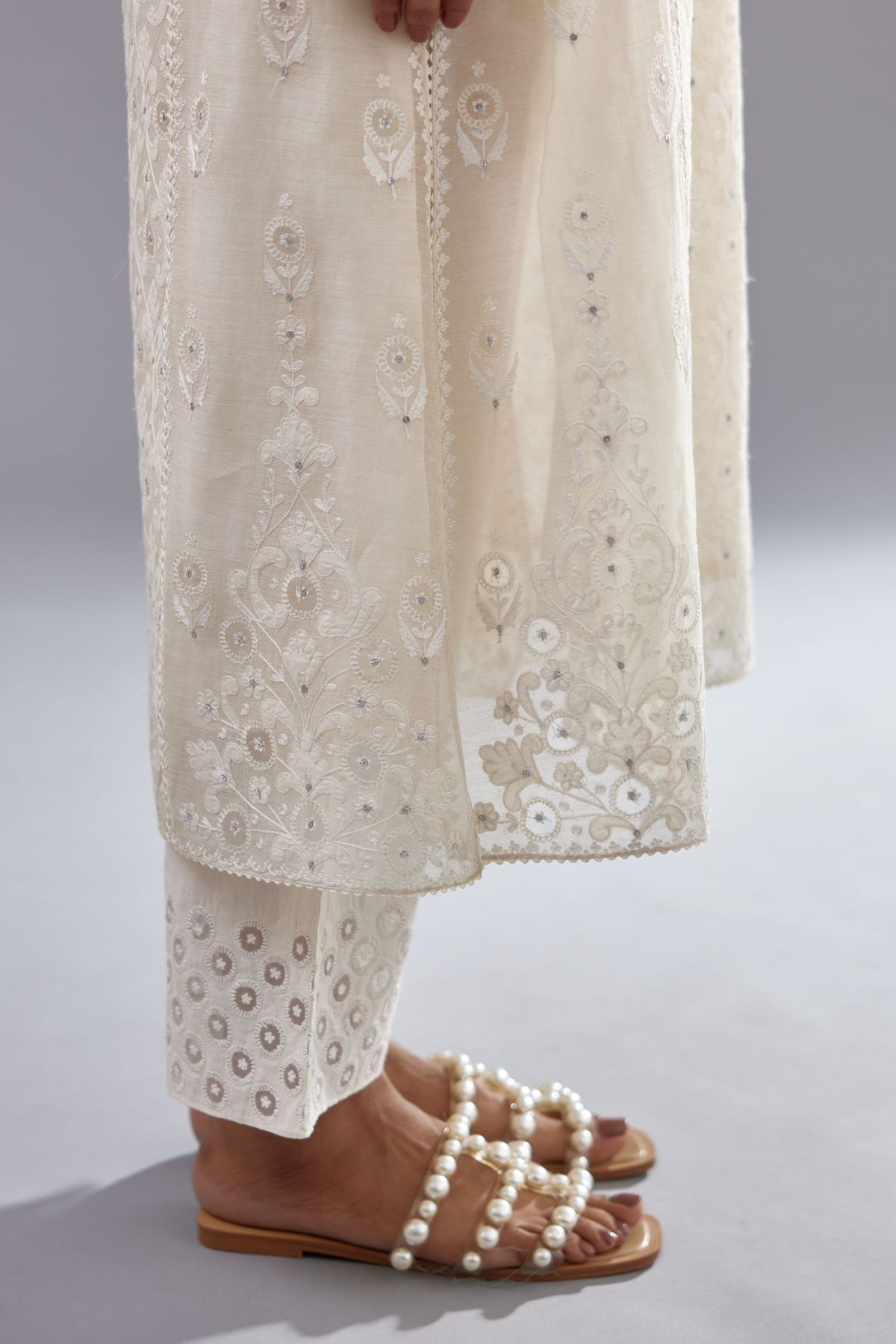 Off white silk chanderi straight kurta set with appliqué trellis jaal in center panel and small assorted flowers embroidery at side panells.