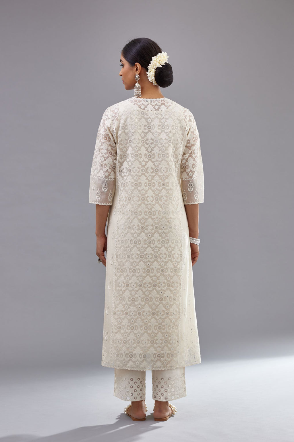 Off white silk chanderi straight kurta set with appliqué trellis jaal in center panel and small assorted flowers embroidery at side panells.
