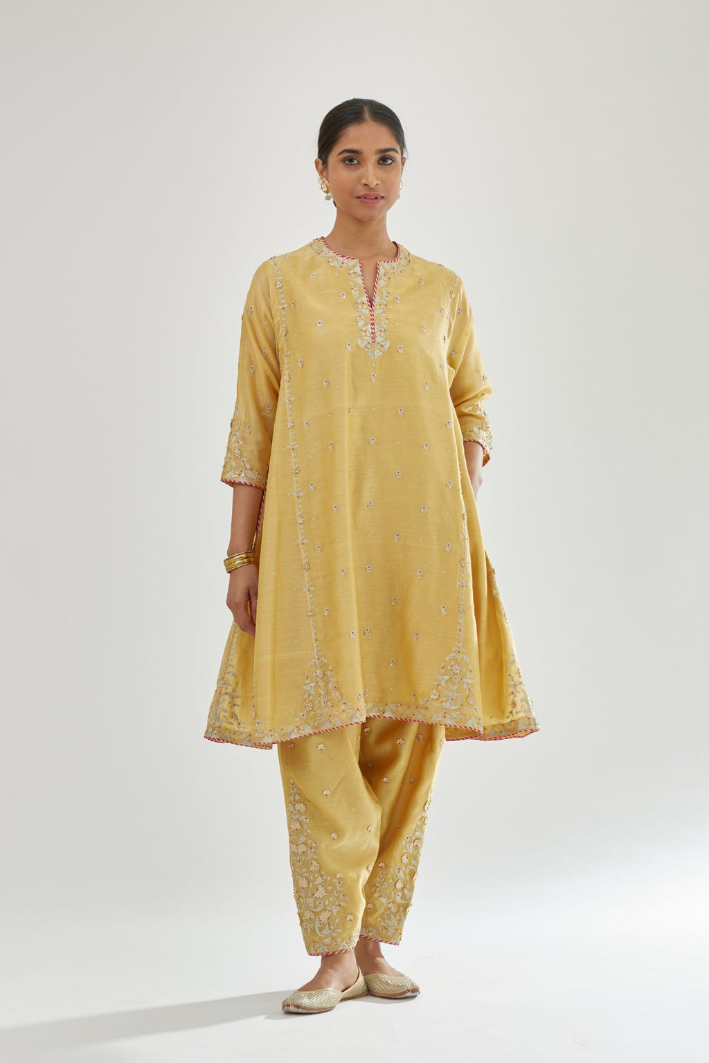 Yellow silk chanderi short kalidar kurta set with all-over delicate zari bootis, detailed with dori embroidery and contrast bead work.