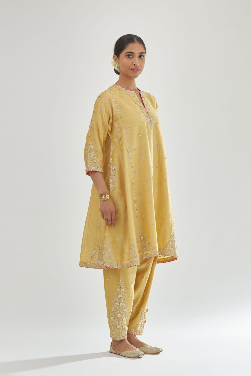 Yellow silk chanderi short kalidar kurta set with all-over delicate zari bootis, detailed with dori embroidery and contrast bead work.