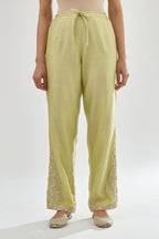 Green silk chanderi straight pants, hem is detailed with zari, dori and gota embroidered boota at sides.