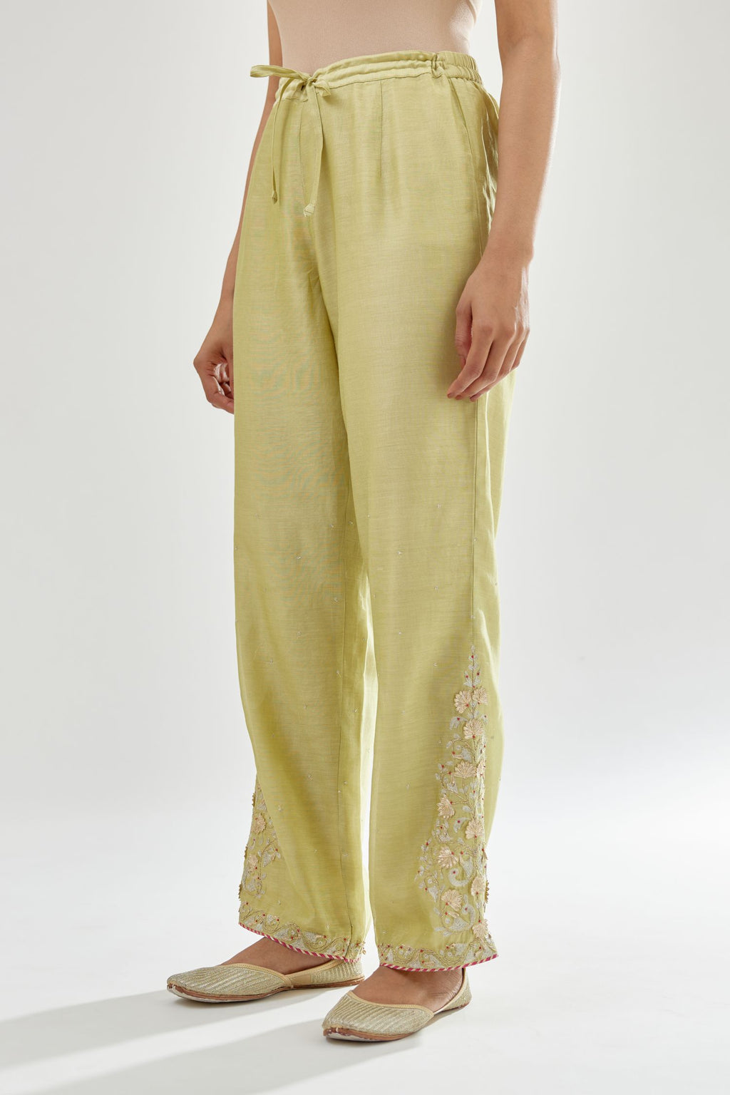 Green silk chanderi straight pants, hem is detailed with zari, dori and gota embroidered boota at sides.