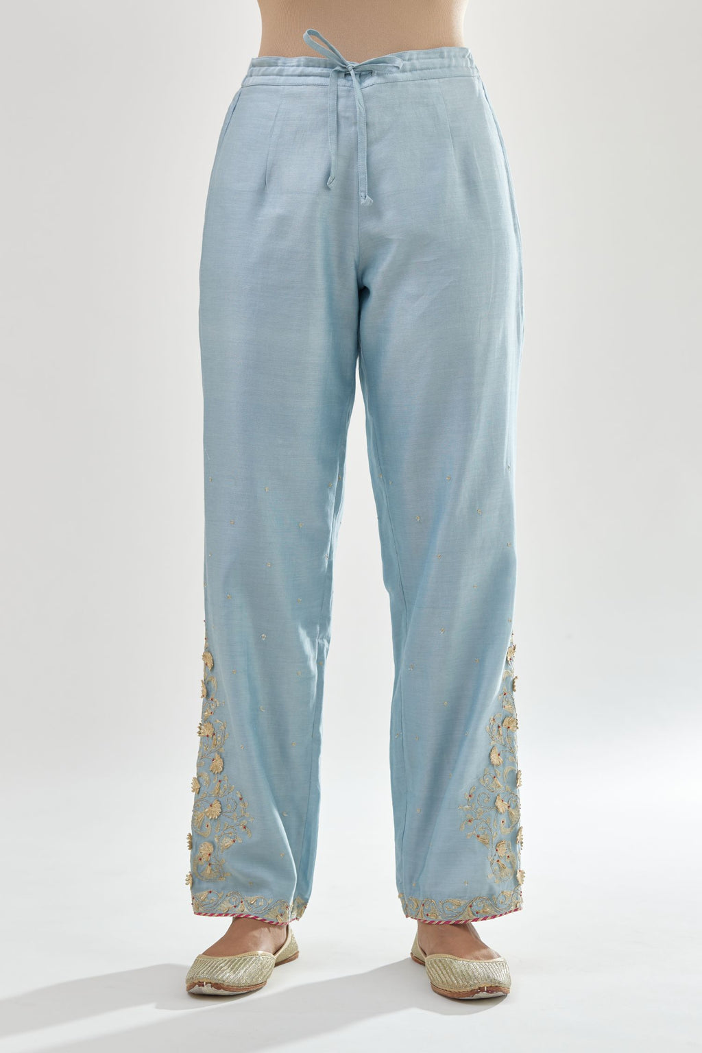 Blue silk chanderi straight pants, hem is detailed with zari, dori and gota embroidered boota at sides.