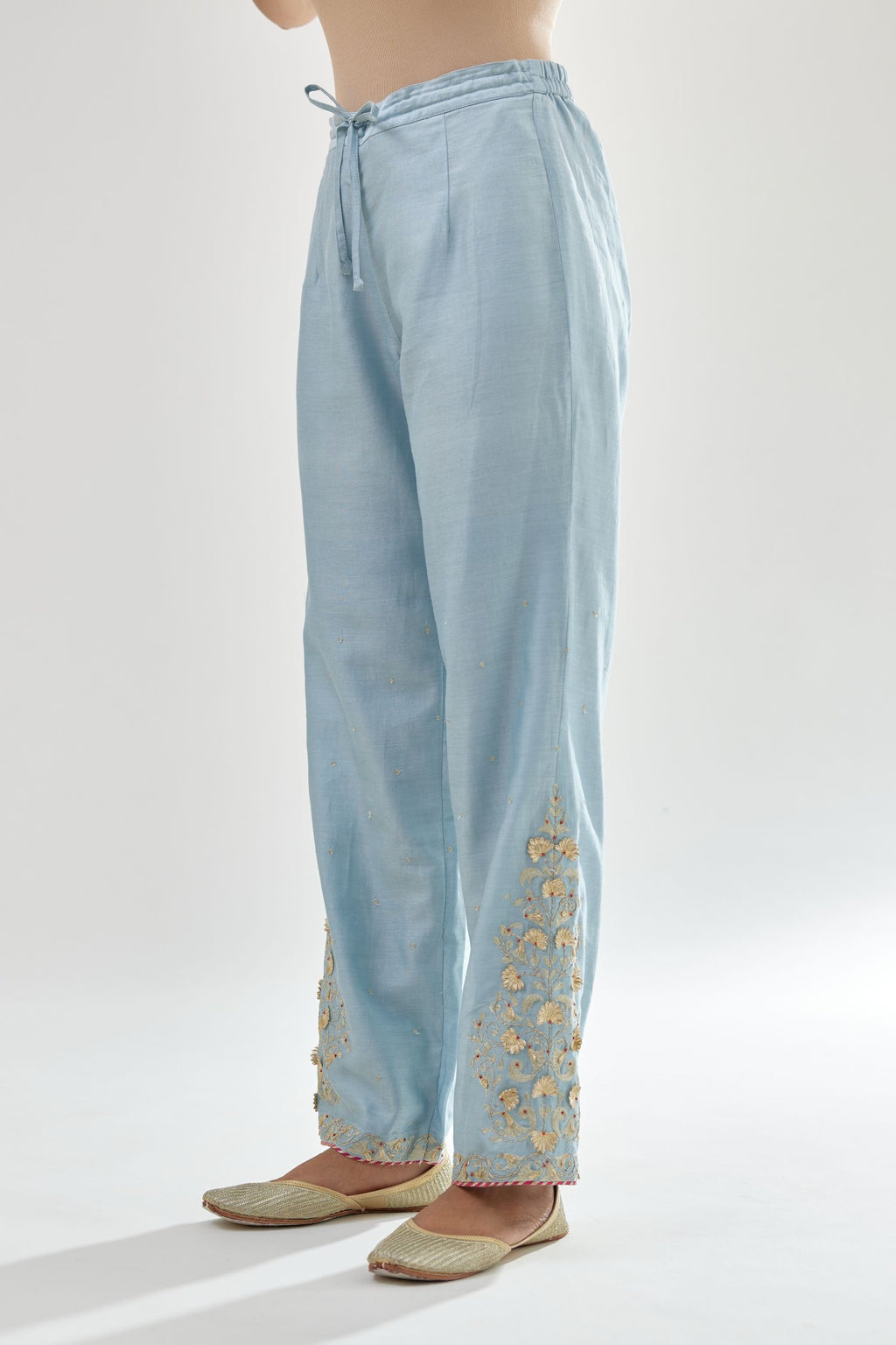 Blue silk chanderi straight pants, hem is detailed with zari, dori and gota embroidered boota at sides.