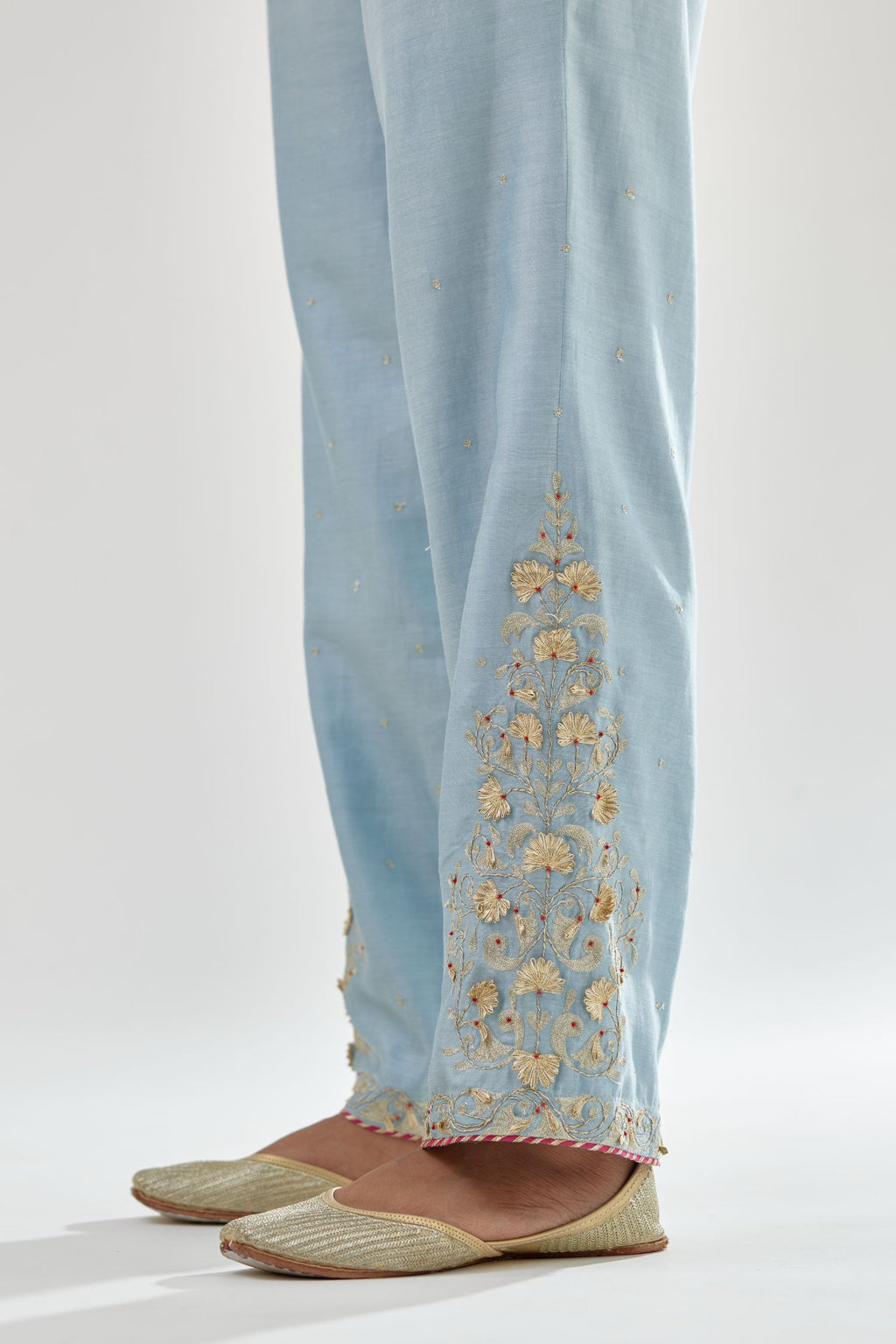 Blue silk chanderi straight pants, hem is detailed with zari, dori and gota embroidered boota at sides.